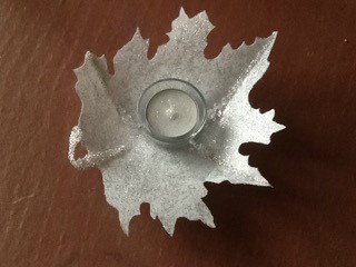 Leaf made from Lutradur 130, coloured with silver glitter glue and embellised with beads with glass tea light holder and tea light positioned in the centre.