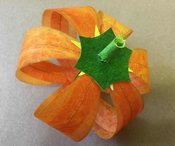 Single pumpkin made of six equal segments, joined at the top and held in position with a green stem, which passes through the pumpkin from top to bottom and helps the pumpkin maintain its shape.