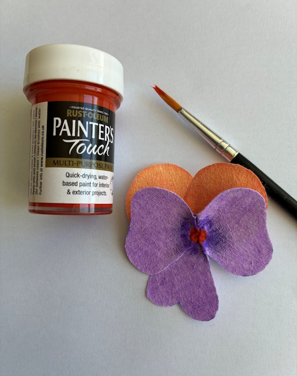 A small dab of brightly coloured paint can be seen to have been added to the very centre of the flower.