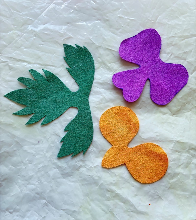 The petals and leaves after they have been cut out from the rest of the fabric.